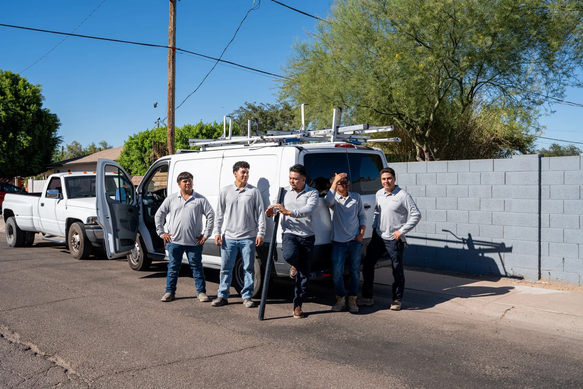 The Warriors Plumbing & Rooter crew lined up beside their Phoenix service trucks